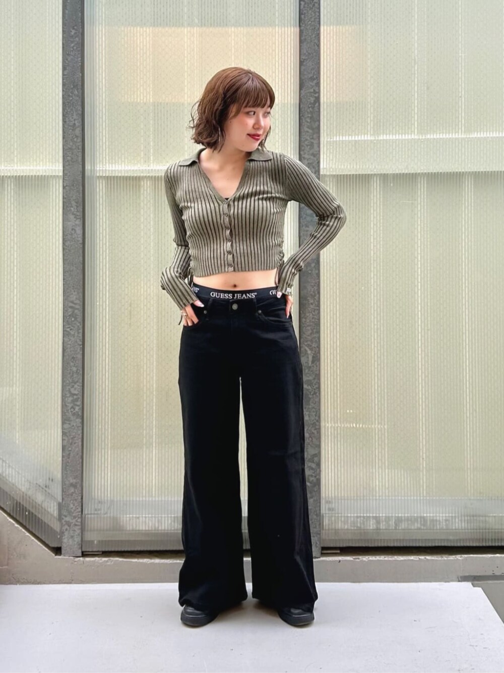 ブラック系のデニムパンツ、グリーン系のカーディガン/ボレロ、ブラック系のボクサーパンツを着用したレディースの秋コーディネートの4枚目の写真