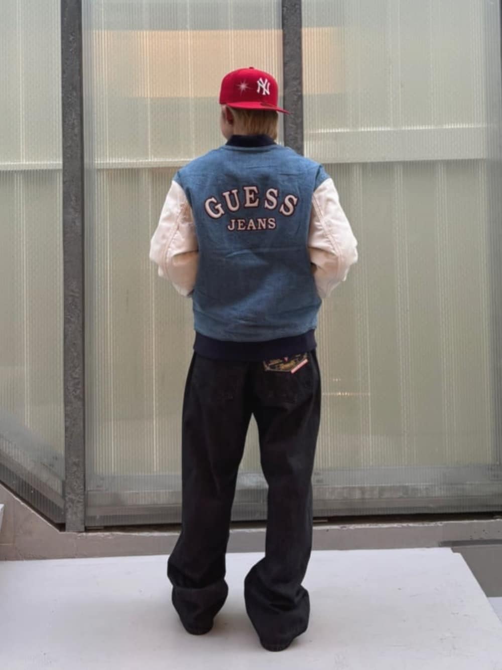 ブラック系のスウェット、ブルー系のスタジャン、ブラック系のデニムパンツを着用したメンズの秋コーディネートの2枚目の写真