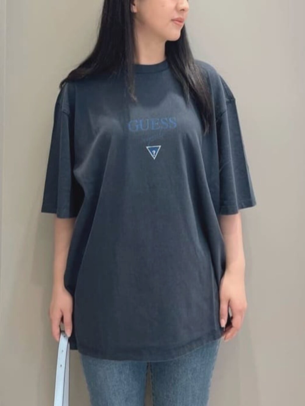 ブルー系のデニムパンツ、ブラック系のTシャツ/カットソー、ブルー系のハンドバッグを着用したレディースの夏コーディネートの5枚目の写真