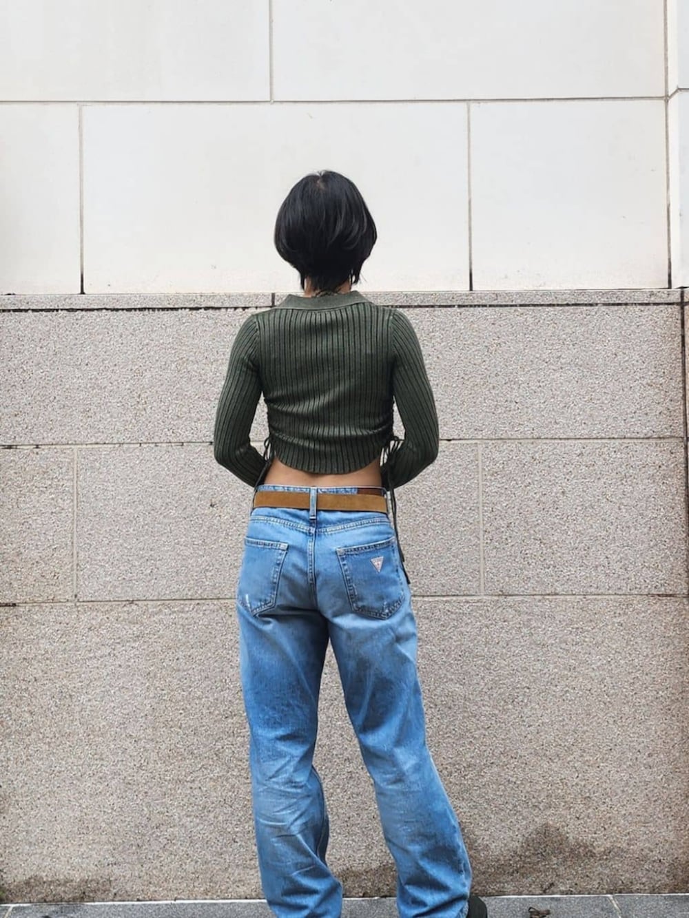 グリーン系のカーディガン/ボレロ、ブルー系のデニムパンツを着用したレディースの秋コーディネートの2枚目の写真