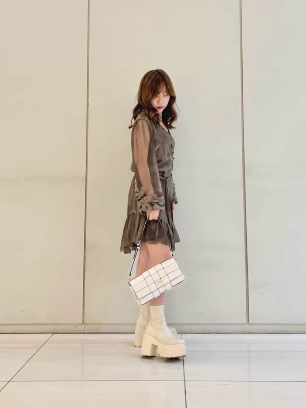 ホワイト系のショルダーバッグ、ブラウン系のワンピース、シルバー系のネックレスを着用したレディースの秋コーディネートの3枚目の写真