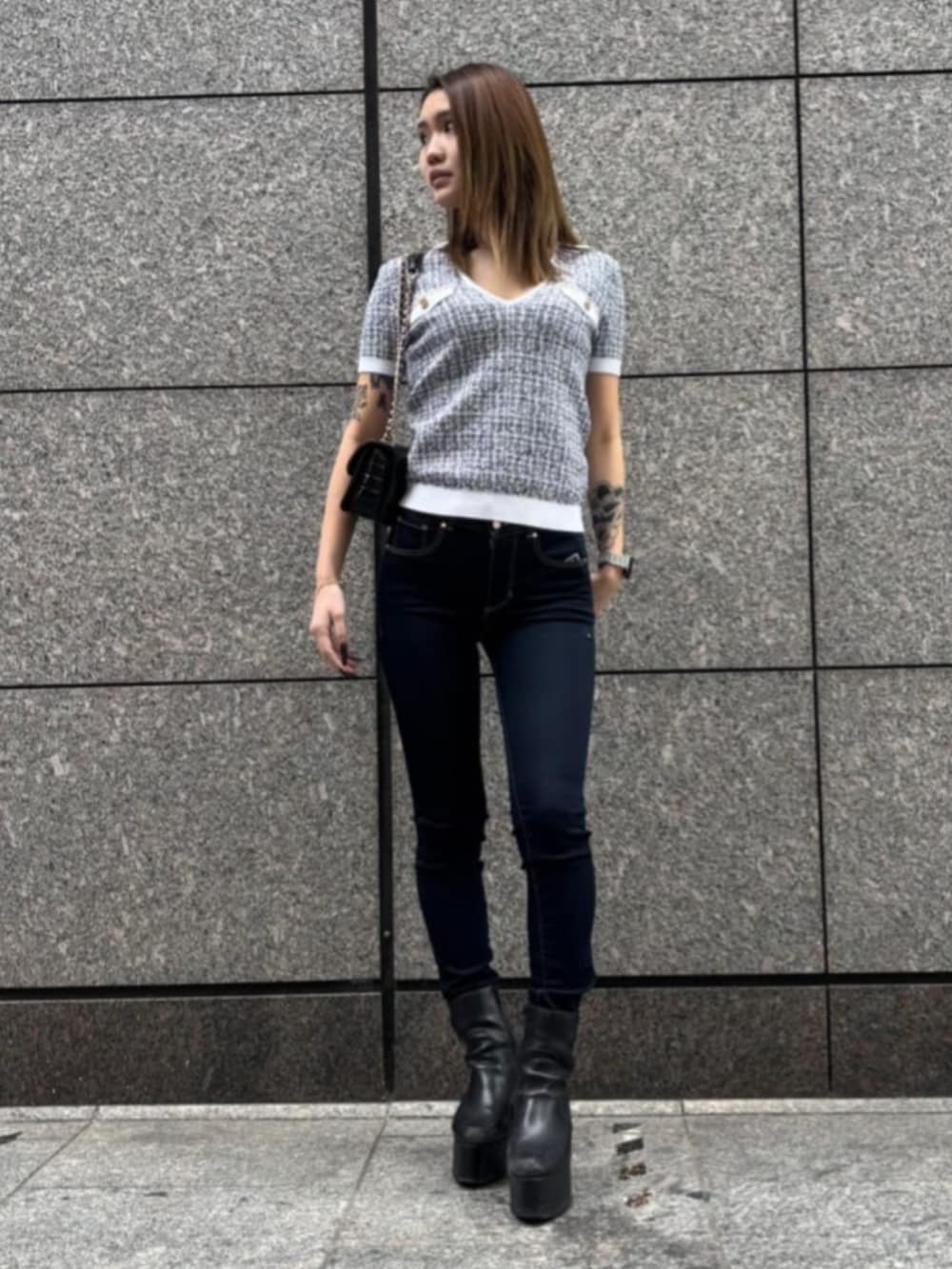 ブルー系のデニムパンツ、ブラック系のショルダーバッグ、ブラック系のニット/セーターを着用したレディースの春コーディネートの2枚目の写真