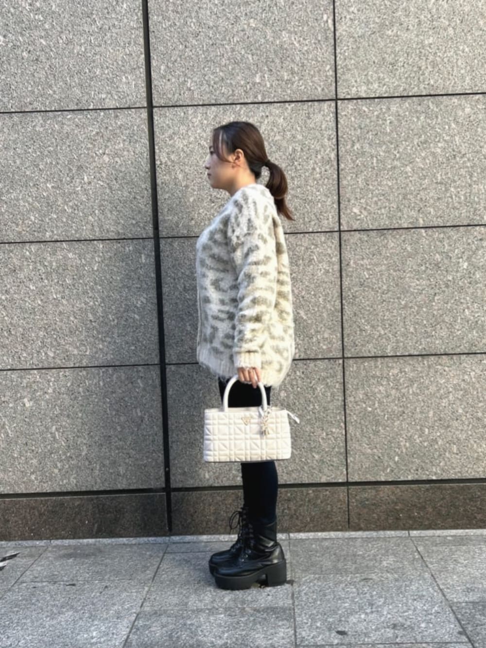 ブルー系のデニムパンツ、ホワイト系のショルダーバッグ、その他のカーディガン/ボレロを着用したレディースの秋コーディネートの3枚目の写真