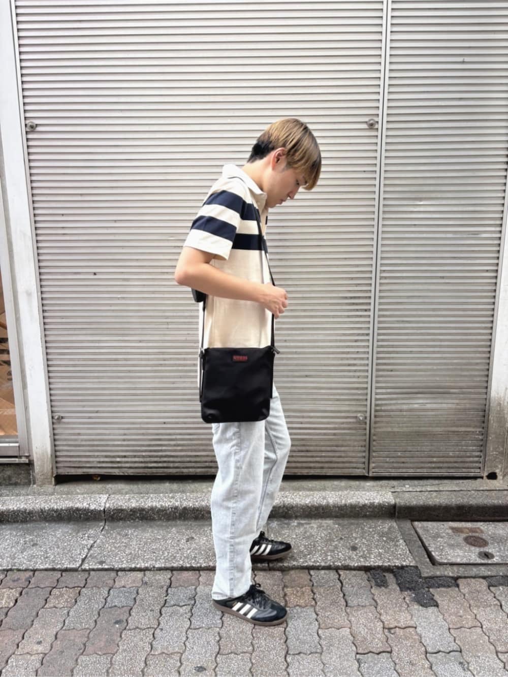 グレー系のデニムパンツ、ホワイト系のポロシャツを着用したメンズの秋コーディネートの3枚目の写真