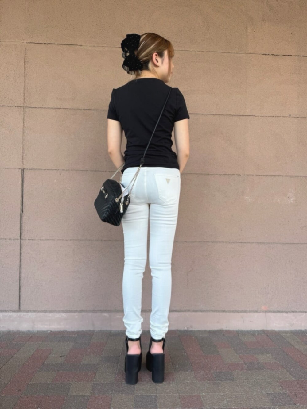 ホワイト系のデニムパンツ、ブラック系のTシャツ/カットソー、ブラック系のショルダーバッグを着用したレディースの冬コーディネートの2枚目の写真