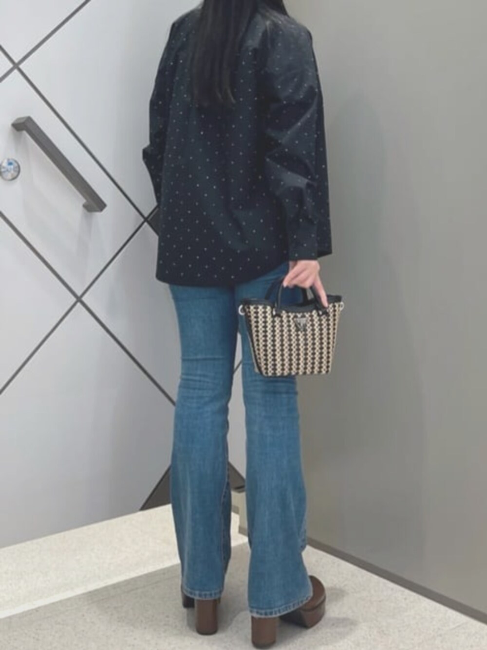 ブルー系のデニムパンツ、ブラック系のタンクトップ、ブラック系のシャツ/ブラウスを着用したレディースの夏コーディネートの2枚目の写真