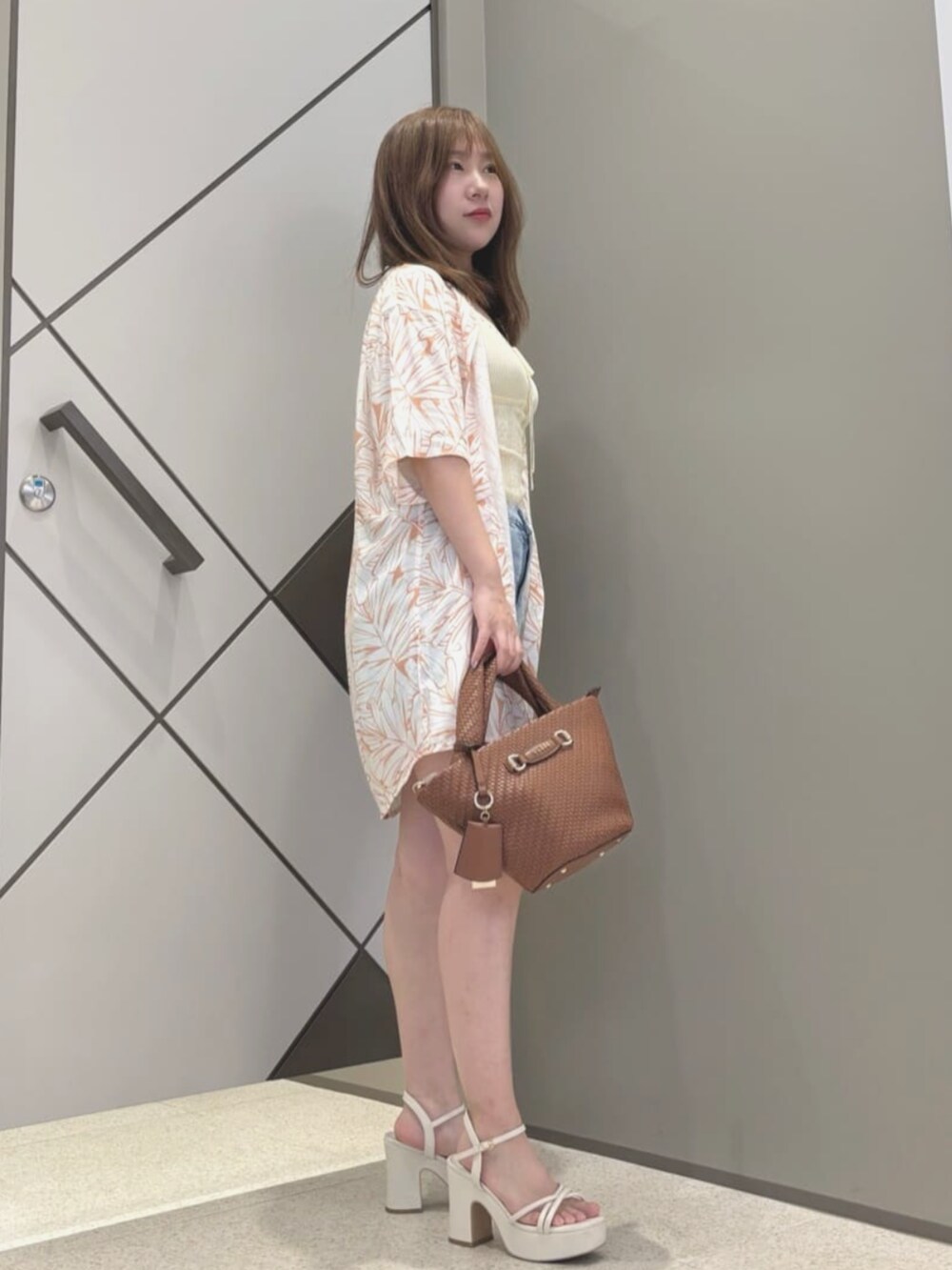 イエロー系のキャミソール、ブルー系のデニムパンツ、オレンジ系のシャツ/ブラウスを着用したレディースの夏コーディネートの3枚目の写真