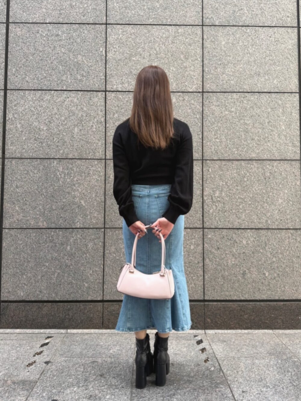 ブルー系のデニムスカート、ピンク系のハンドバッグ、ブラック系のカーディガン/ボレロを着用したレディースの秋コーディネートの2枚目の写真