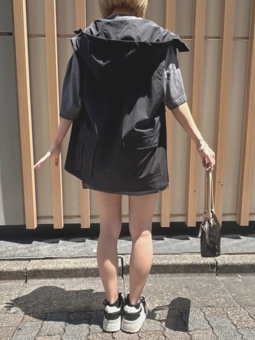 ブラック系のショルダーバッグ、グレー系のTシャツ/カットソー、ブルー系のデニムパンツを着用したレディースの夏コーディネートの2枚目の写真