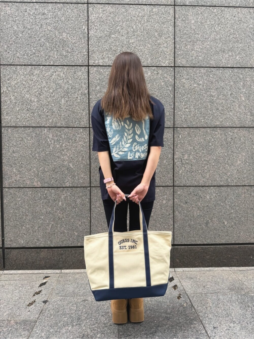 ブルー系のデニムパンツ、ブルー系のトートバッグ、ブルー系のTシャツ/カットソーを着用したレディースの秋コーディネートの2枚目の写真