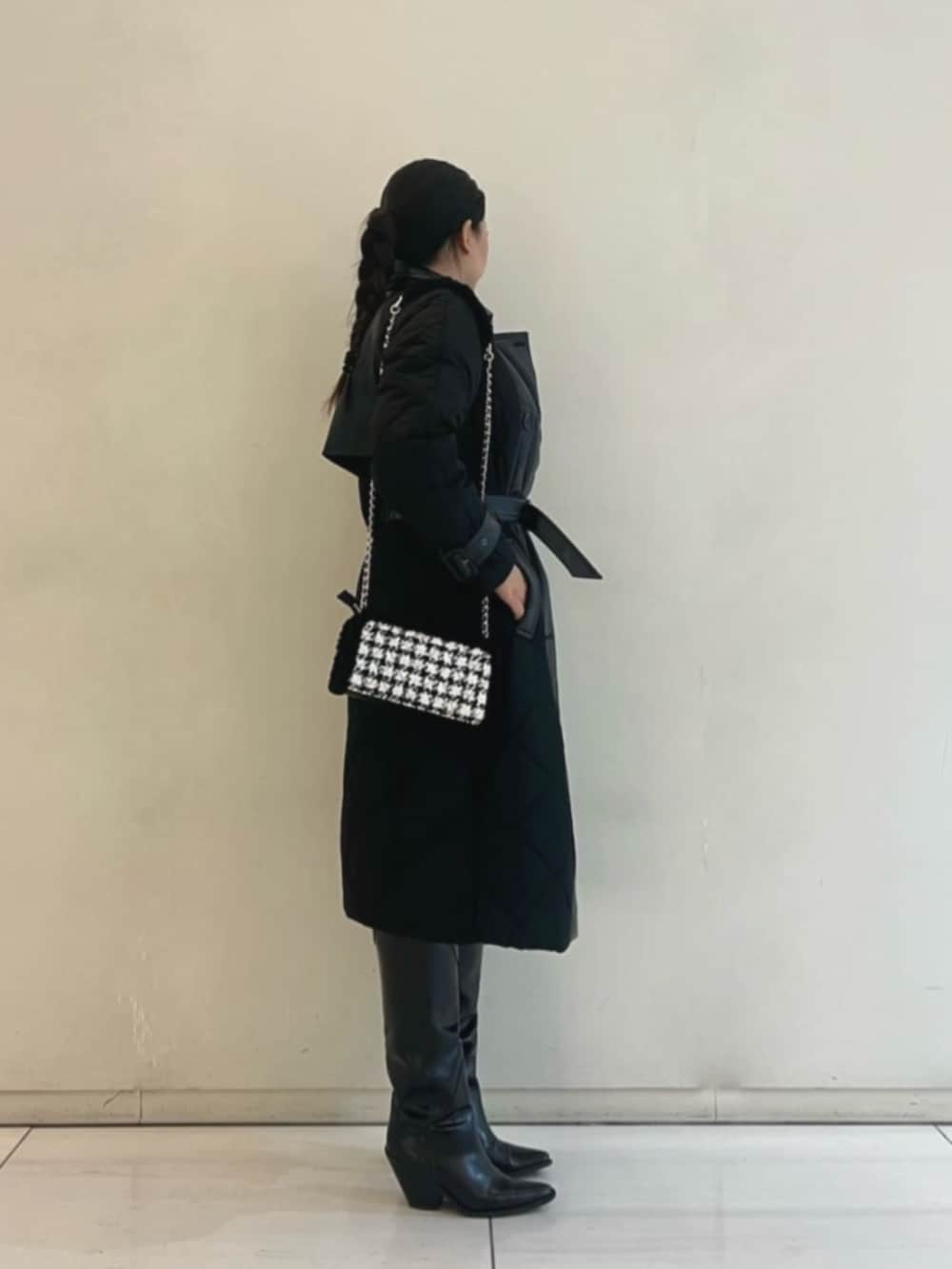 ブラック系のトレンチコート、ブルー系のデニムパンツ、ブラック系のショルダーバッグを着用したレディースの冬コーディネートの3枚目の写真