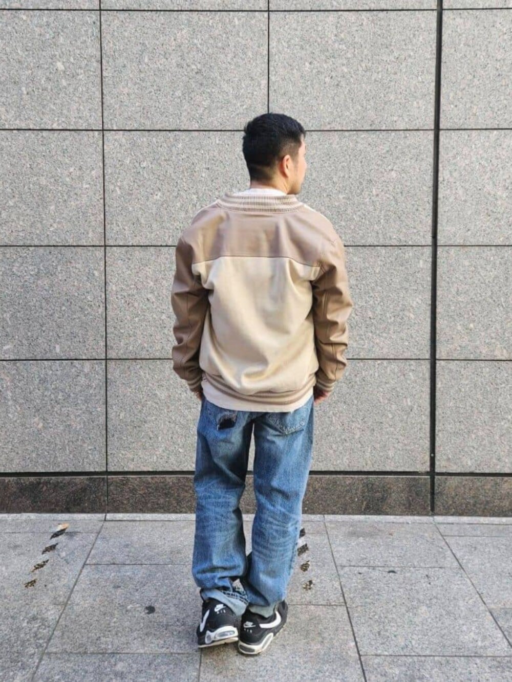 ブルー系のデニムパンツ、ベージュ系のスタジャン、ベージュ系のTシャツ/カットソーを着用したメンズの秋コーディネートの2枚目の写真