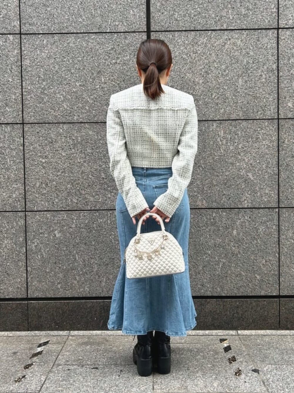ブルー系のデニムスカート、ホワイト系のショルダーバッグ、ホワイト系のその他アウターを着用したレディースの秋コーディネートの2枚目の写真