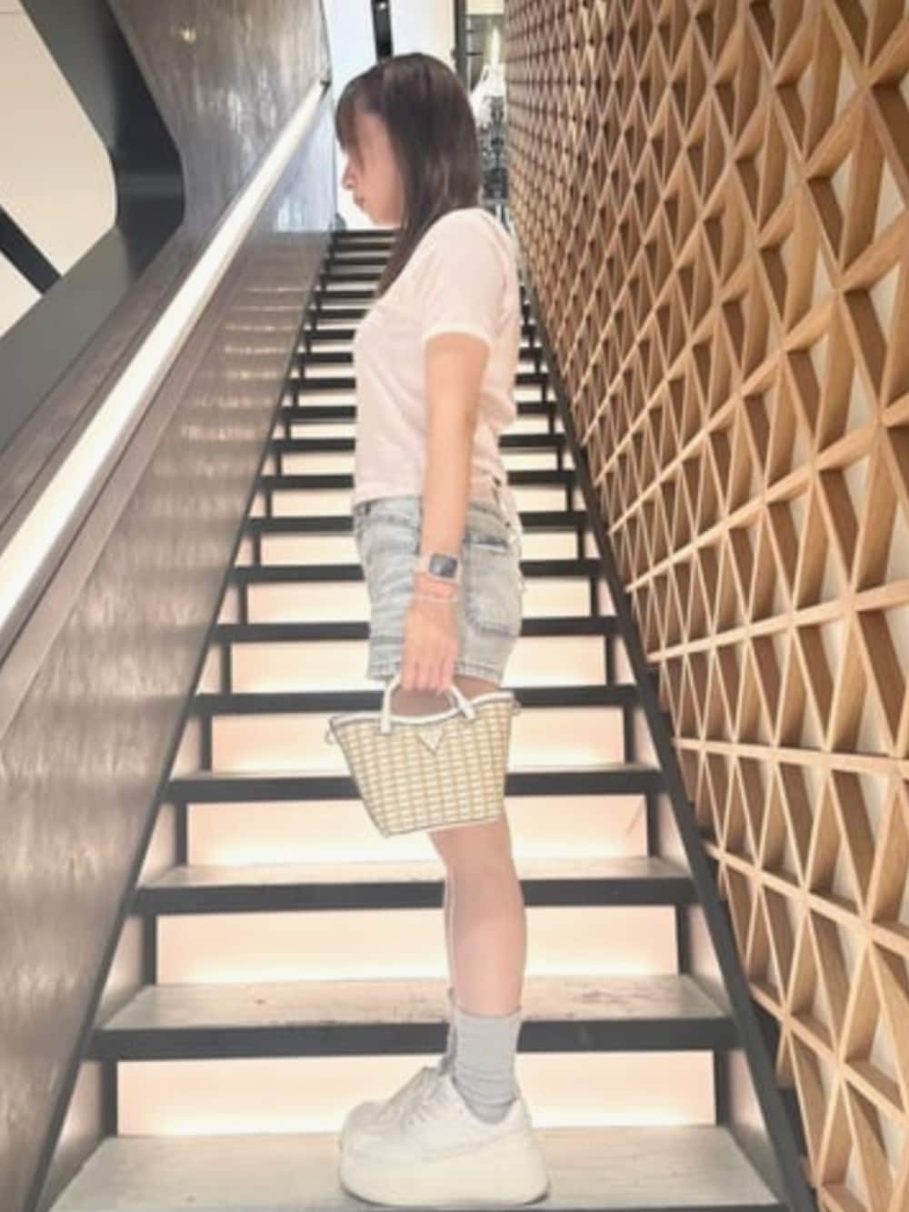 ホワイト系のショルダーバッグ、ブルー系のデニムパンツ、ピンク系のTシャツ/カットソーを着用したレディースの夏コーディネートの3枚目の写真