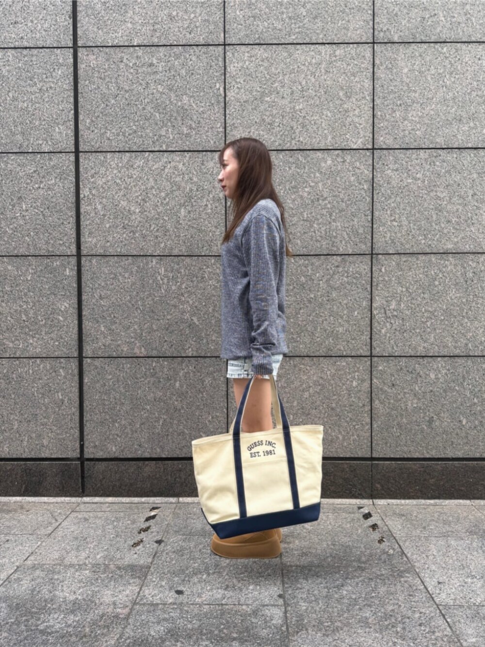 ブルー系のデニムパンツ、ブルー系のトートバッグ、ブルー系のニット/セーターを着用したレディースの秋コーディネートの3枚目の写真