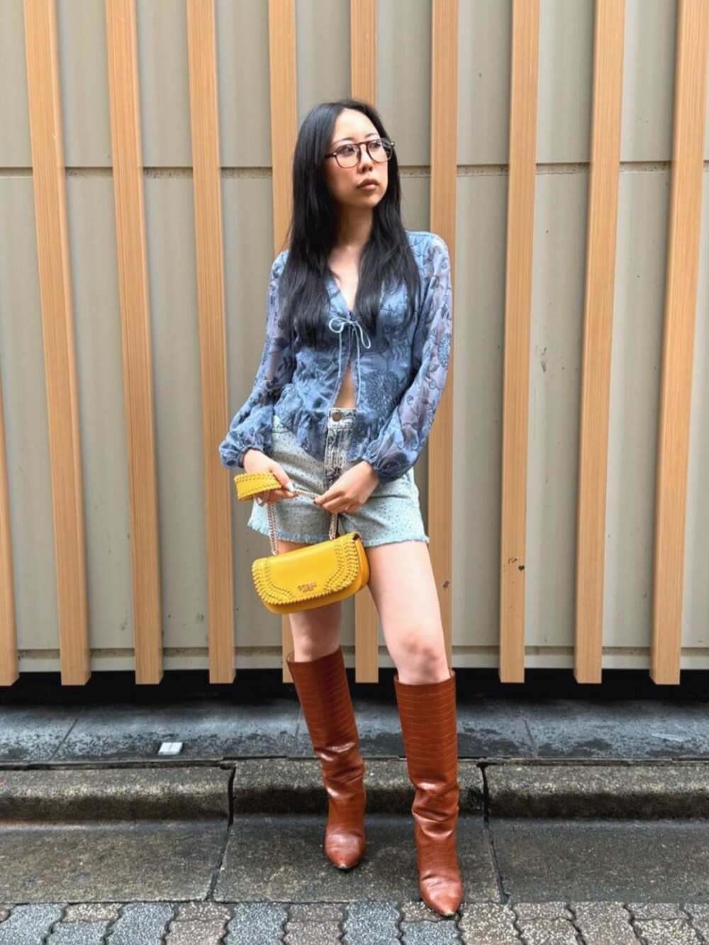 ブルー系のデニムパンツ、ブルー系のシャツ/ブラウス、オレンジ系のショルダーバッグを着用したレディースの秋コーディネートの4枚目の写真