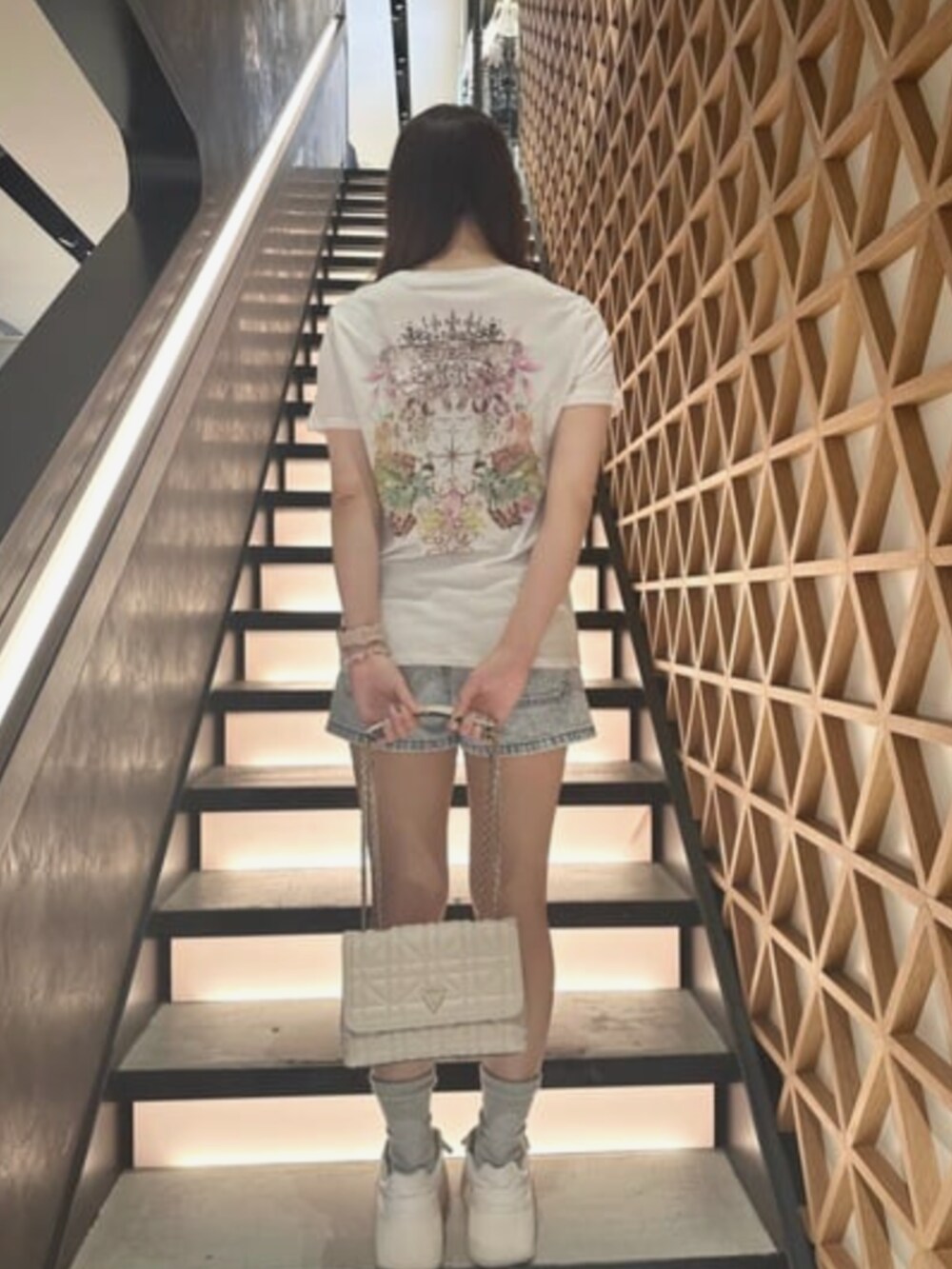 ブルー系のデニムパンツ、ホワイト系のTシャツ/カットソー、ホワイト系のショルダーバッグを着用したレディースの夏コーディネートの2枚目の写真