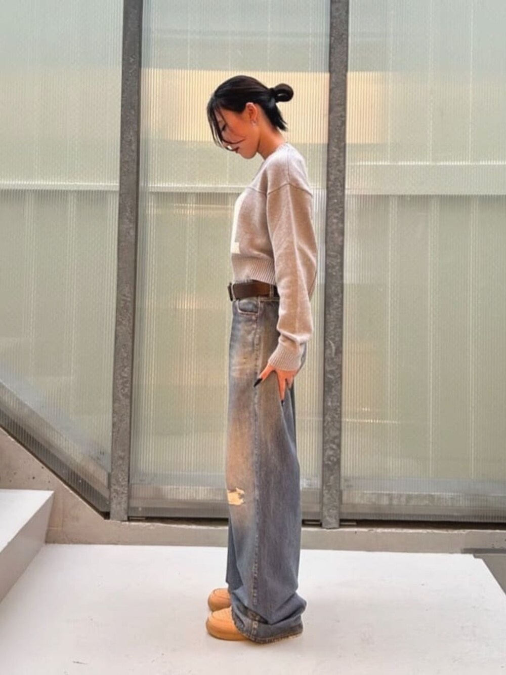 ブルー系のデニムパンツ、グレー系のニット/セーターを着用したレディースの秋コーディネートの3枚目の写真