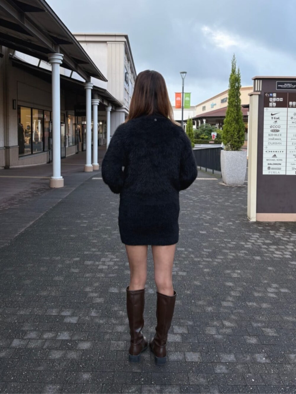 ブラック系のワンピース、パープル系のショルダーバッグを着用したレディースの秋コーディネートの2枚目の写真