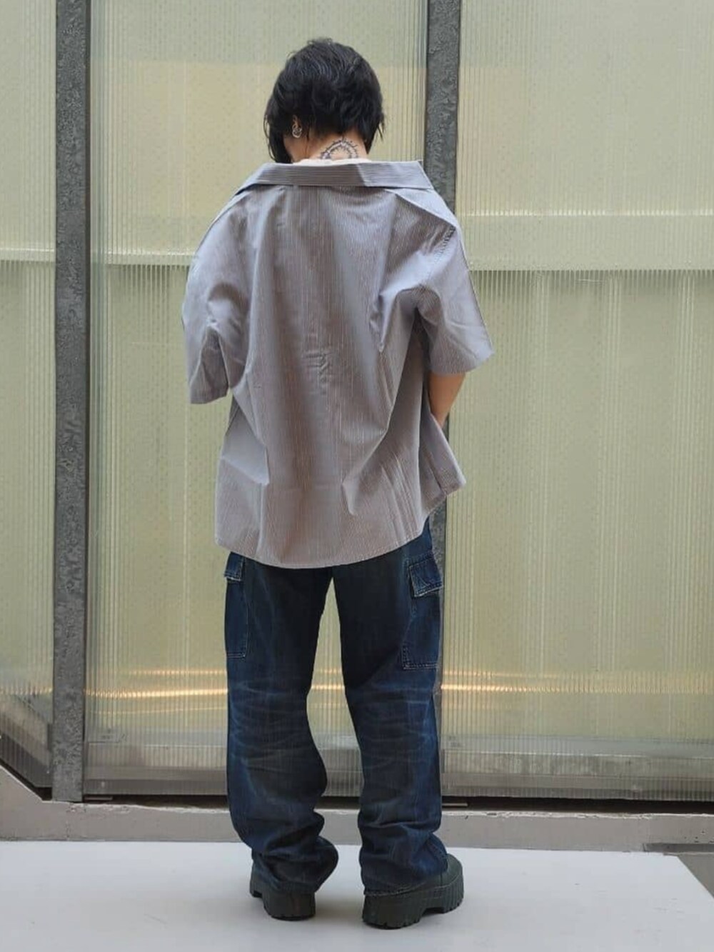ホワイト系のTシャツ/カットソー、グレー系のシャツ/ブラウス、ブルー系のデニムパンツを着用したレディースの秋コーディネートの2枚目の写真