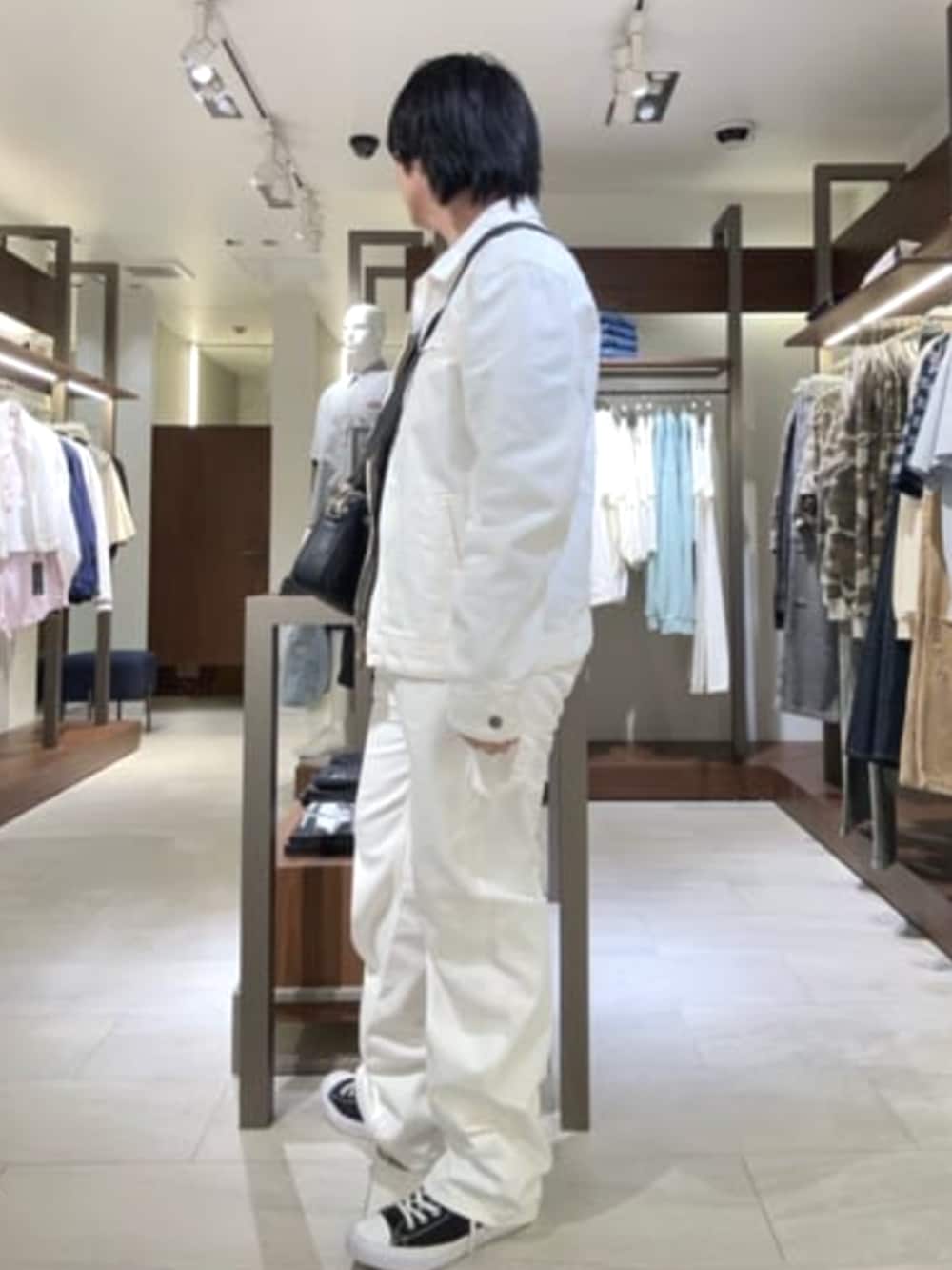 ブラック系のショルダーバッグ、ホワイト系のデニムジャケット、ホワイト系のカーゴパンツを着用したメンズの夏コーディネートの3枚目の写真