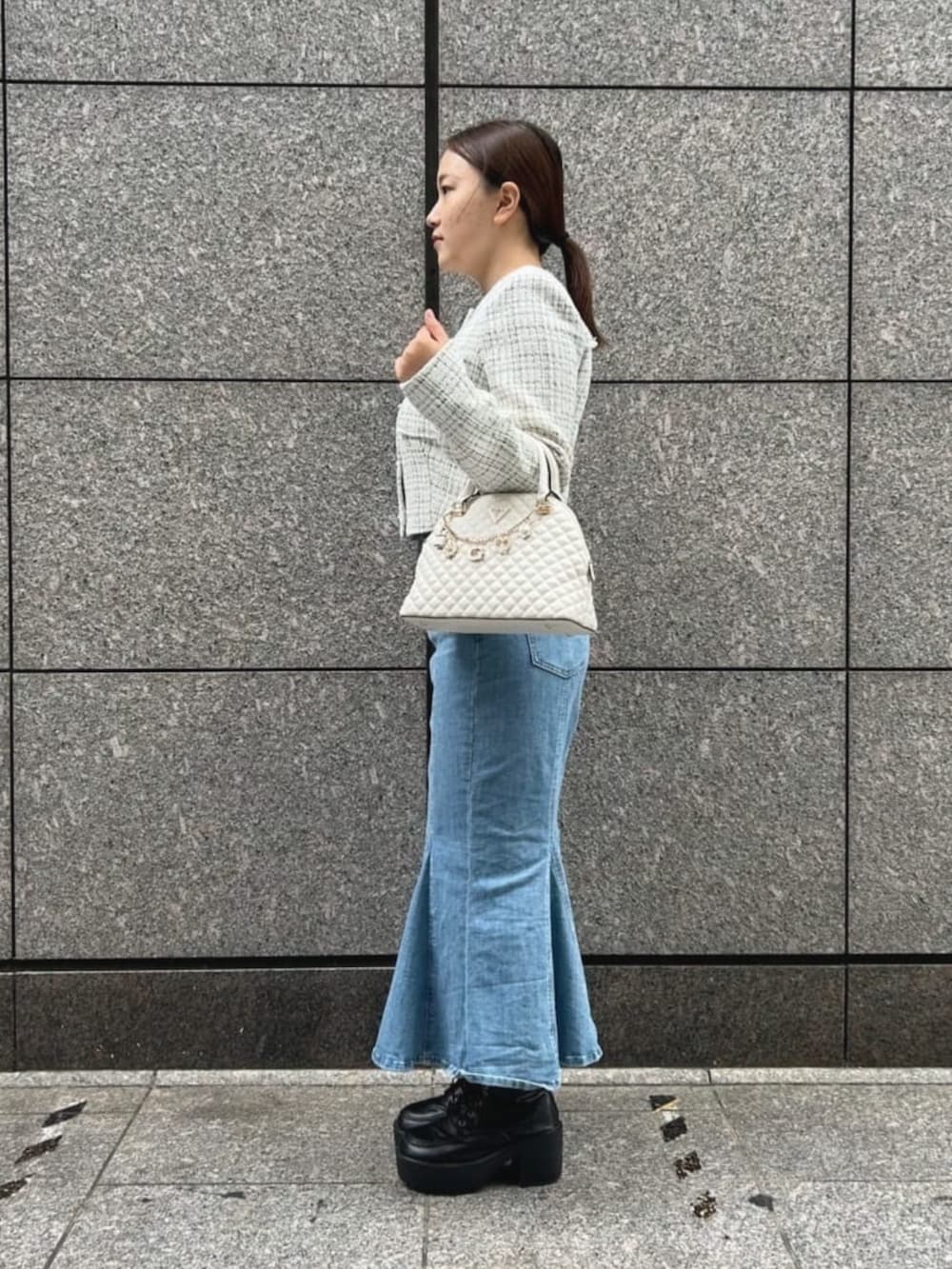 ブルー系のデニムスカート、ホワイト系のショルダーバッグ、ホワイト系のその他アウターを着用したレディースの秋コーディネートの3枚目の写真