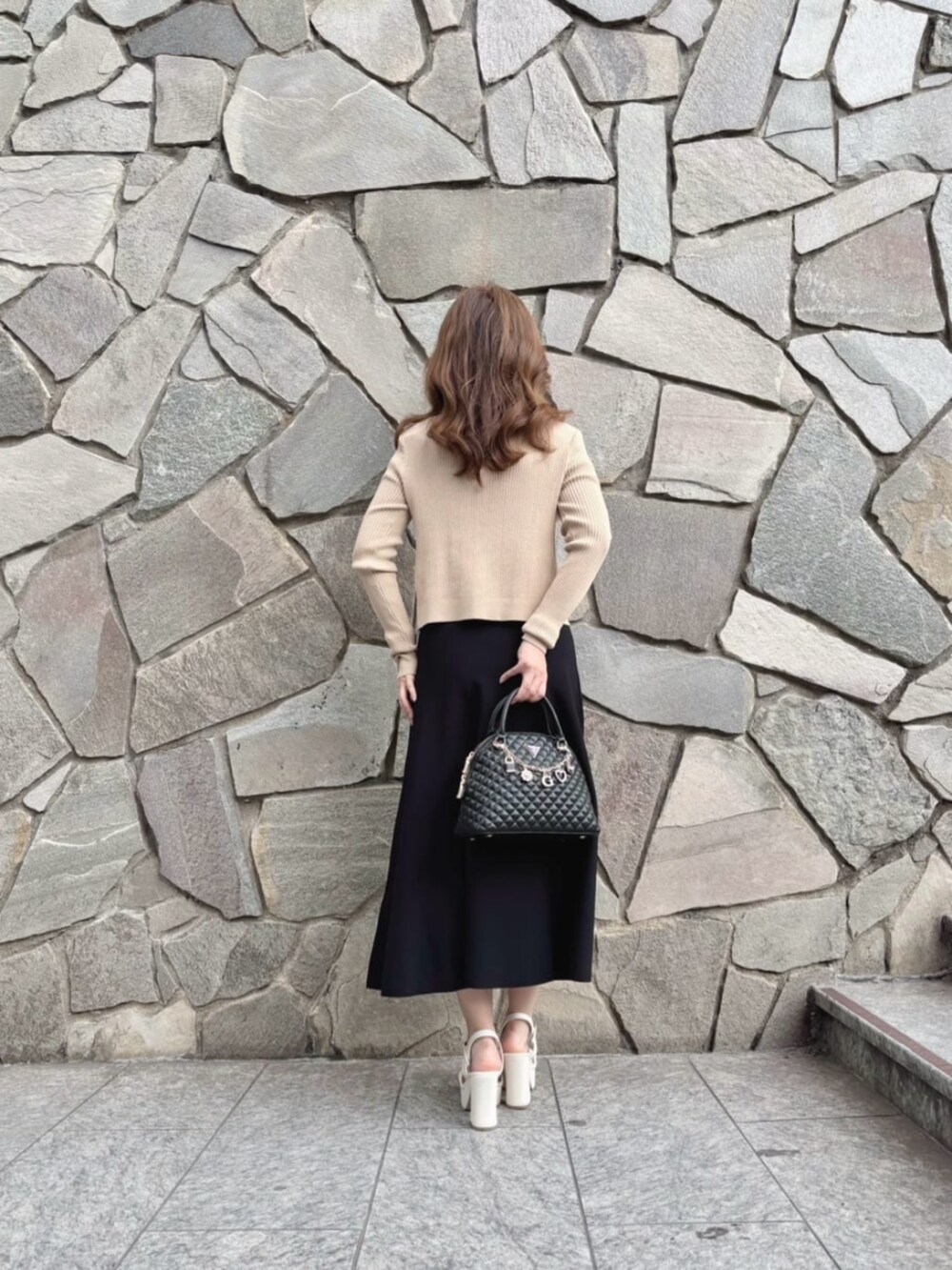 ベージュ系のカーディガン/ボレロ、ブラック系のワンピース、ブラック系のショルダーバッグを着用したレディースの秋コーディネートの2枚目の写真