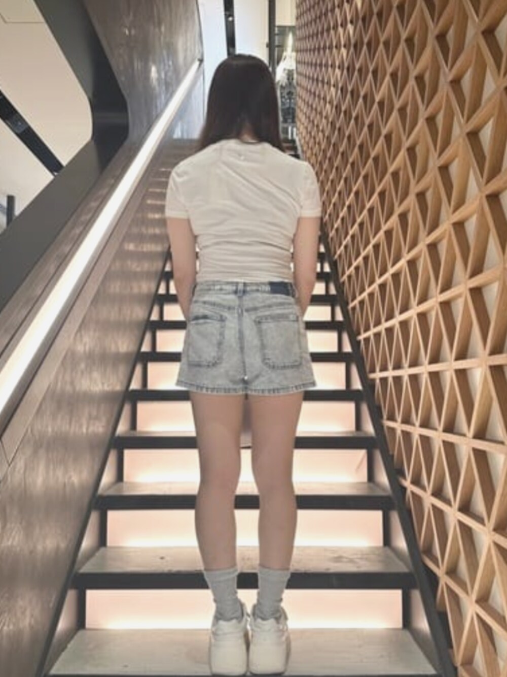 ベージュ系のTシャツ/カットソー、ブルー系のデニムパンツ、ホワイト系のショルダーバッグを着用したレディースの夏コーディネートの2枚目の写真