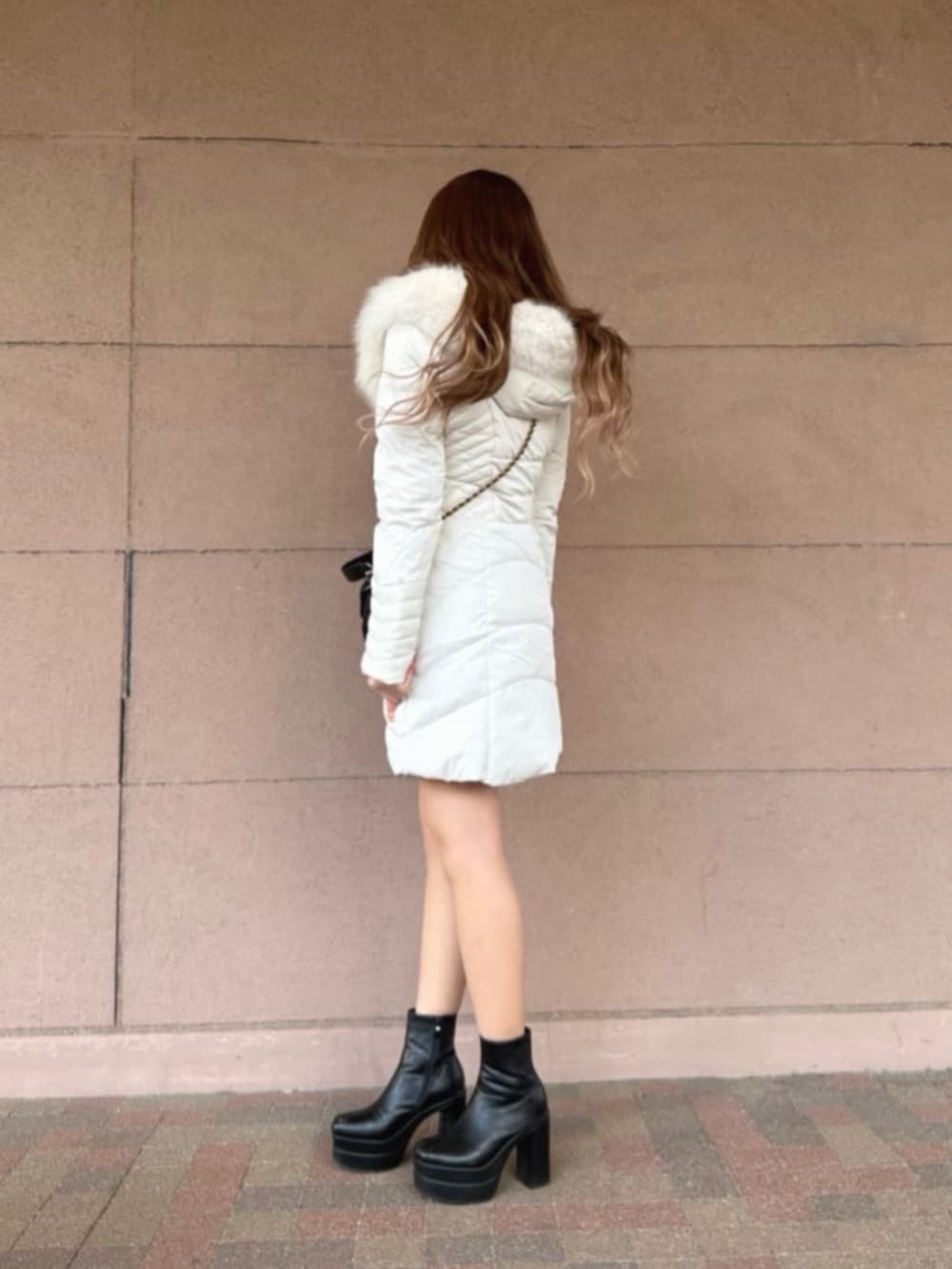 ブラック系のショルダーバッグ、ブラック系のスカート、ベージュ系のニット/セーターを着用したレディースの冬コーディネートの3枚目の写真