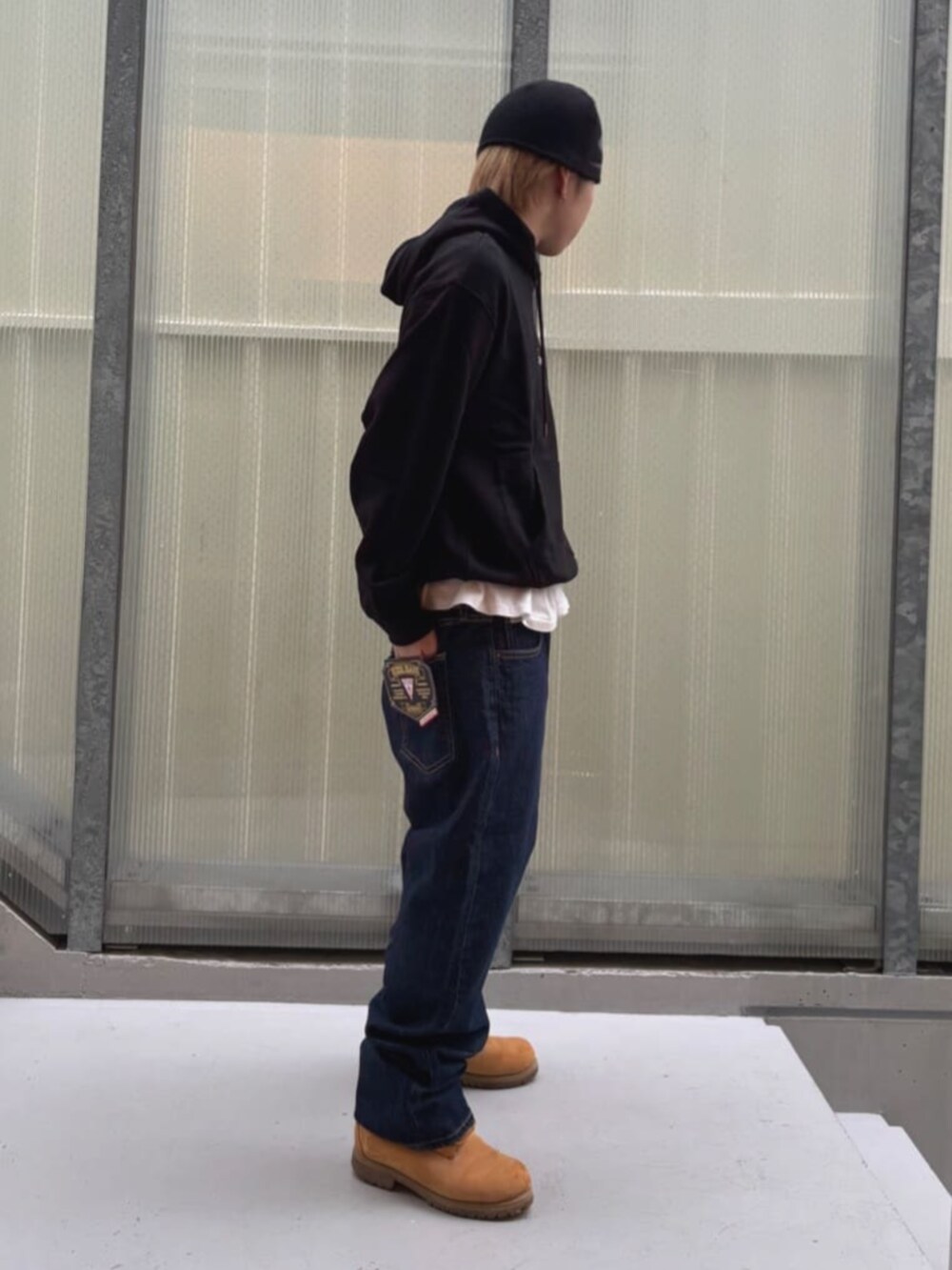 ブルー系のデニムパンツ、ホワイト系のTシャツ/カットソー、ブラック系のパーカーを着用したメンズの秋コーディネートの3枚目の写真