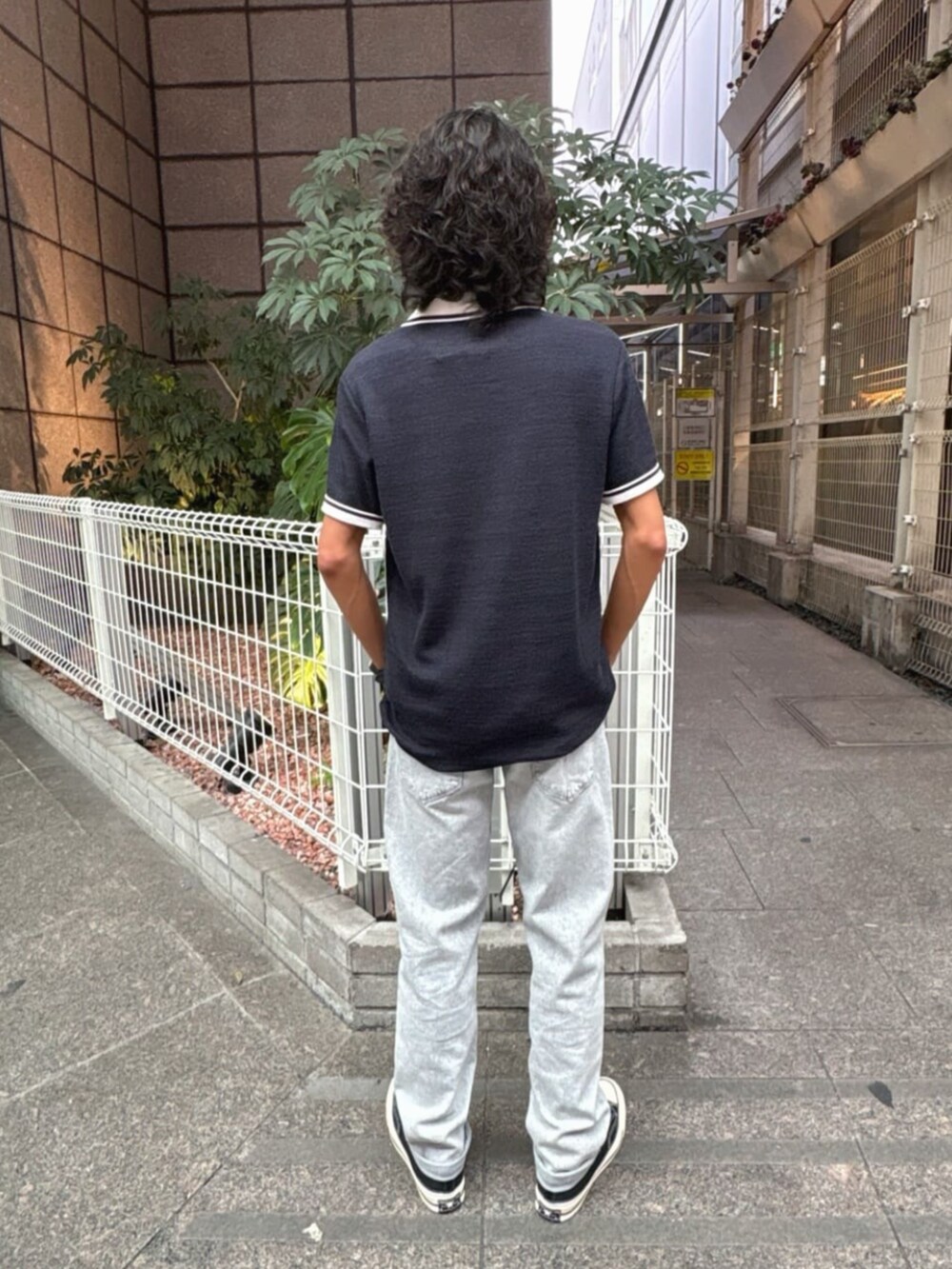 ブルー系のポロシャツ、グレー系のデニムパンツを着用したメンズの夏コーディネートの2枚目の写真