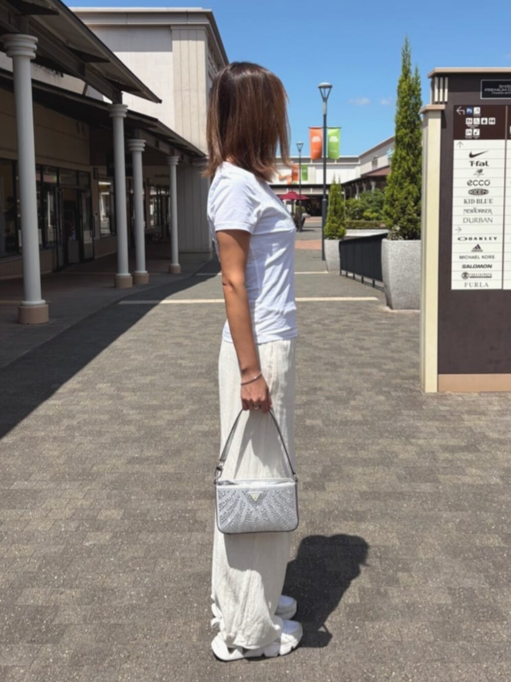 シルバー系のハンドバッグを着用したレディースの夏コーディネートの3枚目の写真