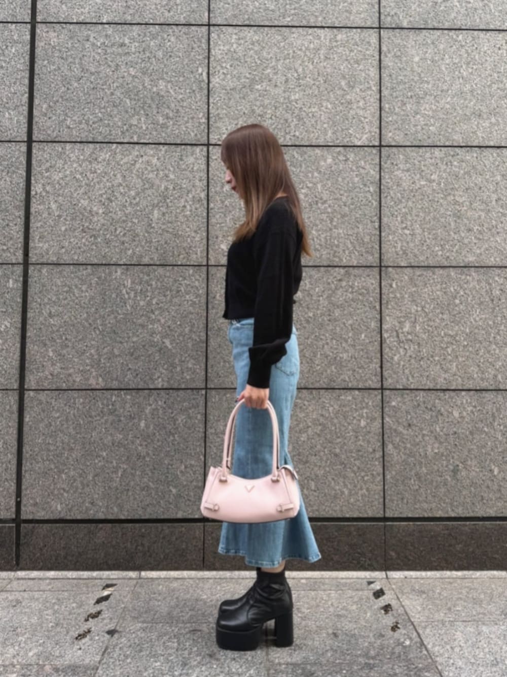 ブルー系のデニムスカート、ピンク系のハンドバッグ、ブラック系のカーディガン/ボレロを着用したレディースの秋コーディネートの3枚目の写真