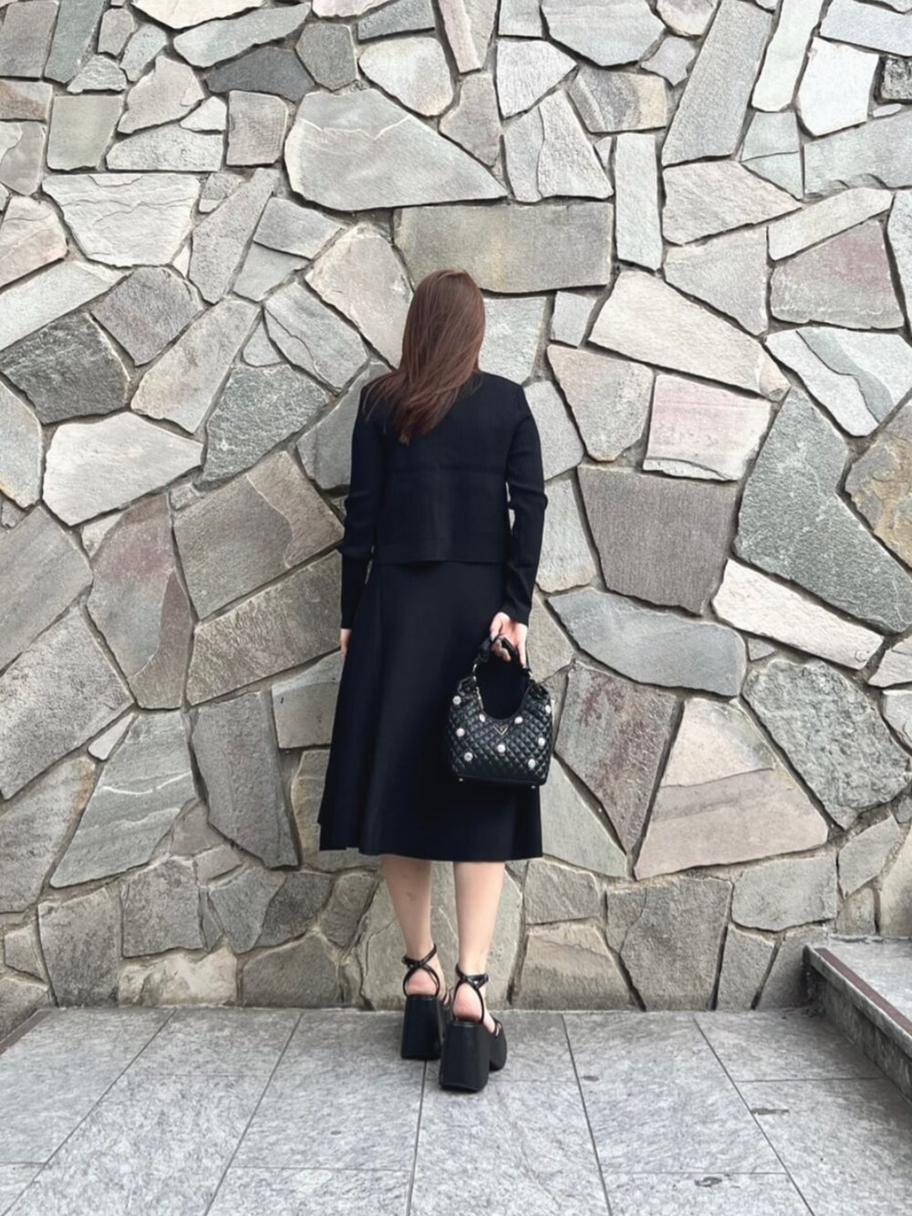 ブラック系のショルダーバッグ、ブラック系のワンピース、ブラック系のカーディガン/ボレロを着用したレディースの秋コーディネートの2枚目の写真
