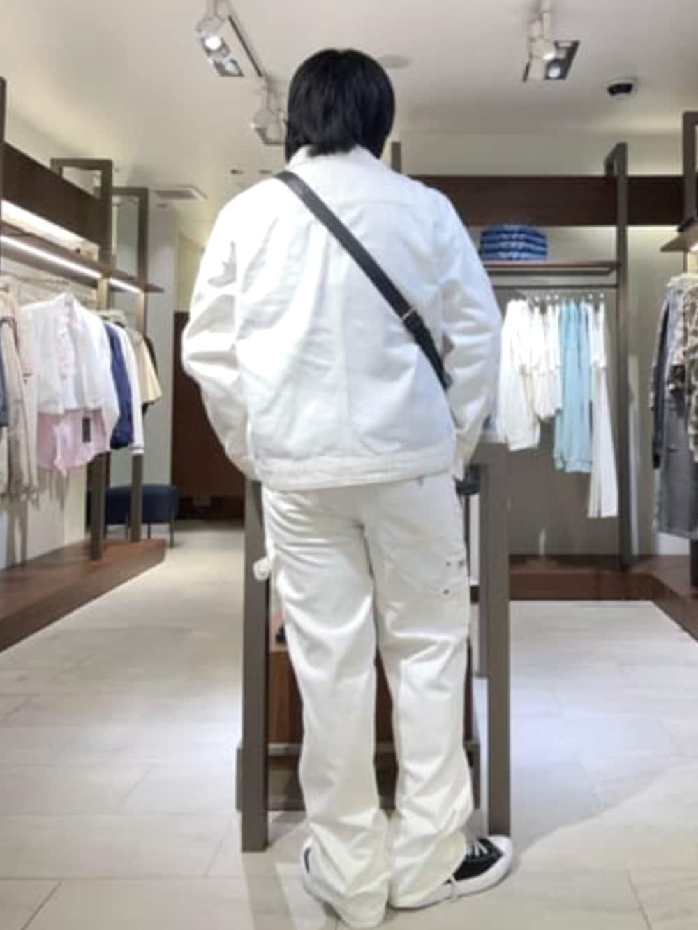 ブラック系のショルダーバッグ、ホワイト系のデニムジャケット、ホワイト系のカーゴパンツを着用したメンズの夏コーディネートの2枚目の写真