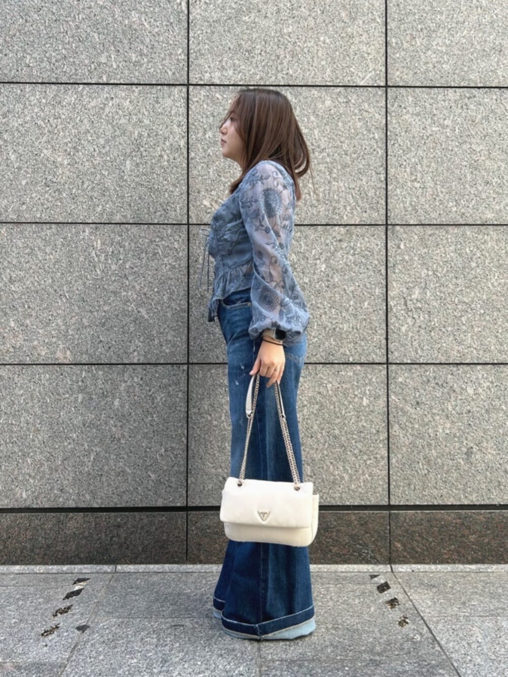 ブルー系のデニムパンツ、ブルー系のシャツ/ブラウス、ホワイト系のショルダーバッグを着用したレディースの秋コーディネートの3枚目の写真