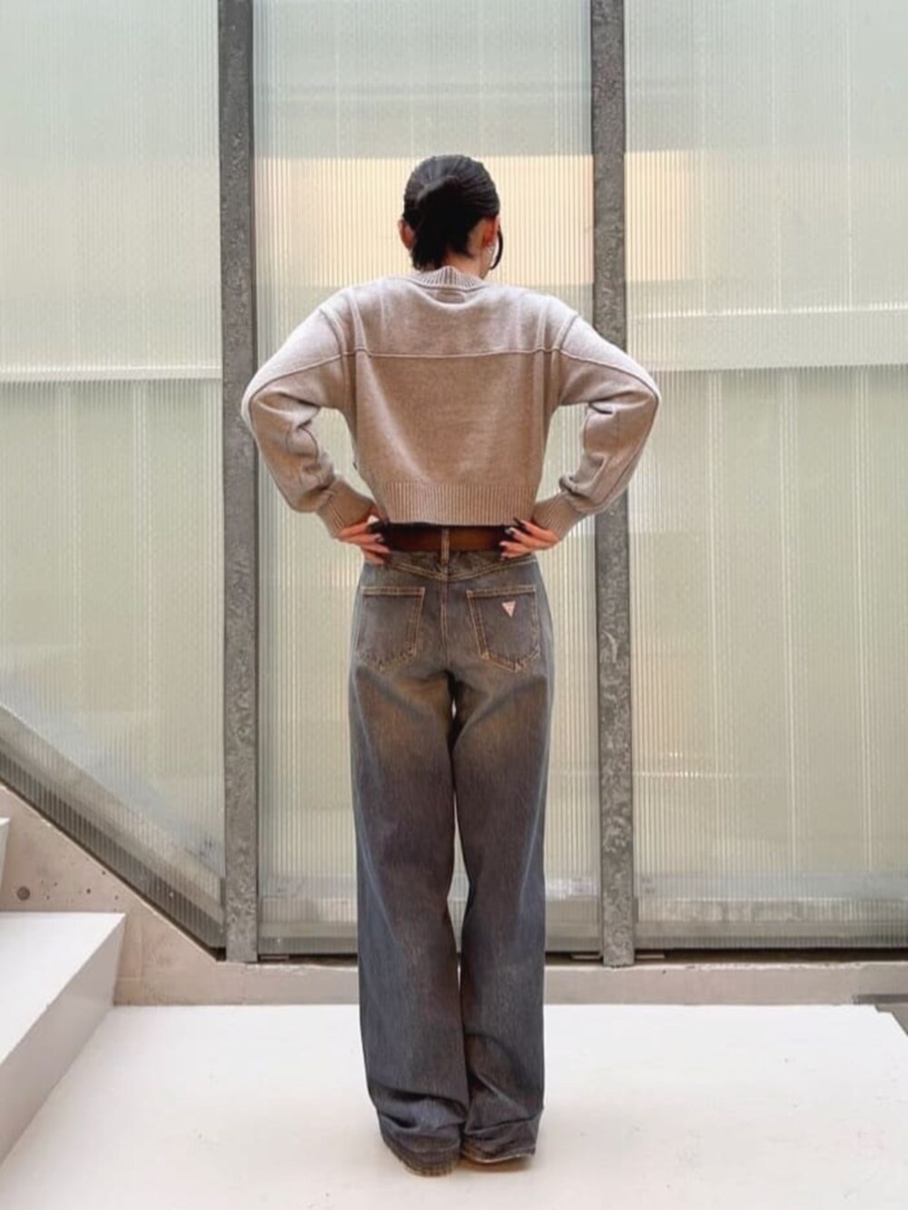 ブルー系のデニムパンツ、グレー系のニット/セーターを着用したレディースの秋コーディネートの2枚目の写真