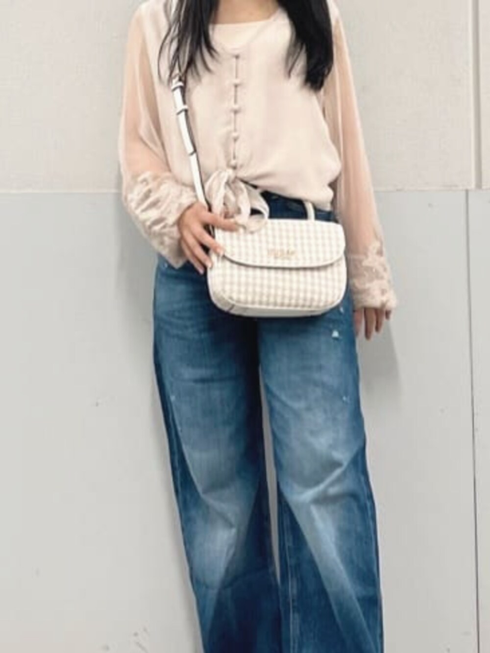 ベージュ系のシャツ/ブラウス、ホワイト系のショルダーバッグ、ブルー系のデニムパンツを着用したレディースの秋コーディネートの4枚目の写真