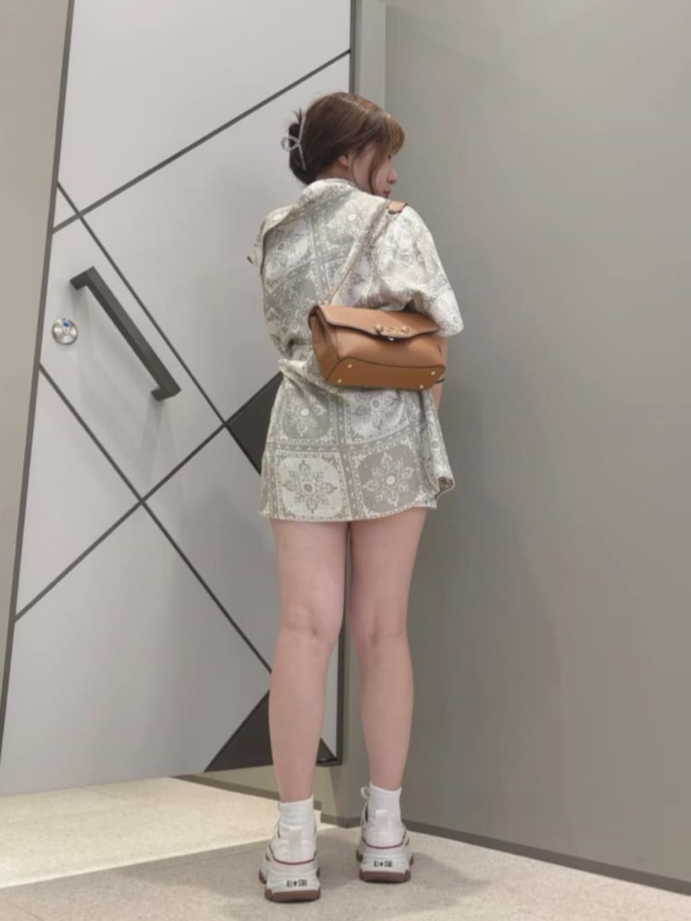 ベージュ系のシャツ/ブラウス、イエロー系のショルダーバッグ、ブラック系のタンクトップを着用したレディースの夏コーディネートの2枚目の写真