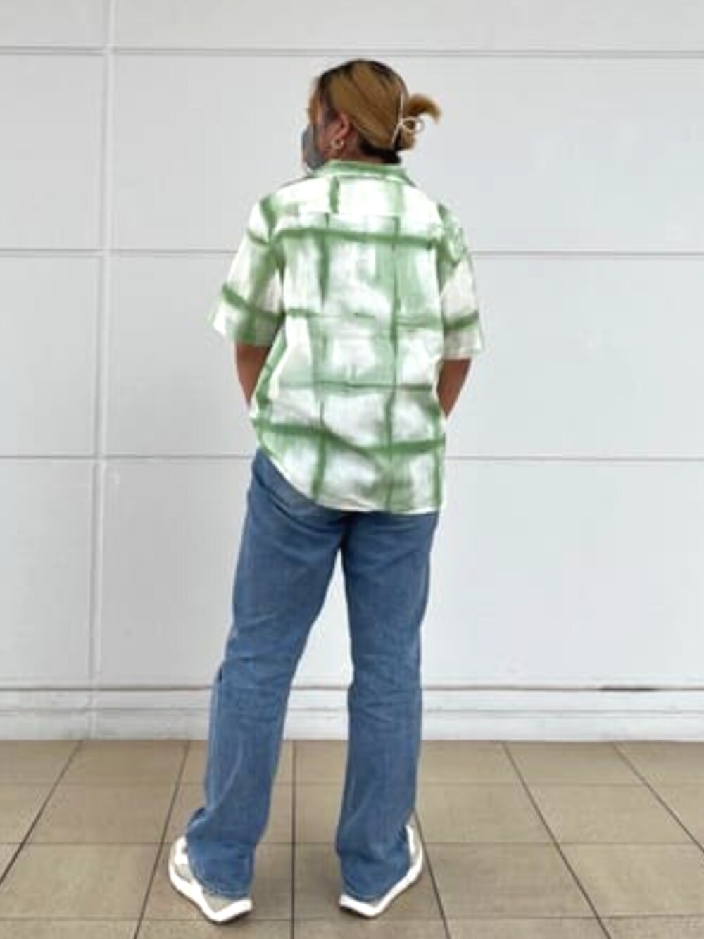 ブルー系のデニムパンツ、グリーン系のシャツ/ブラウス、ゴールド系のネックレスを着用したレディースの夏コーディネートの2枚目の写真