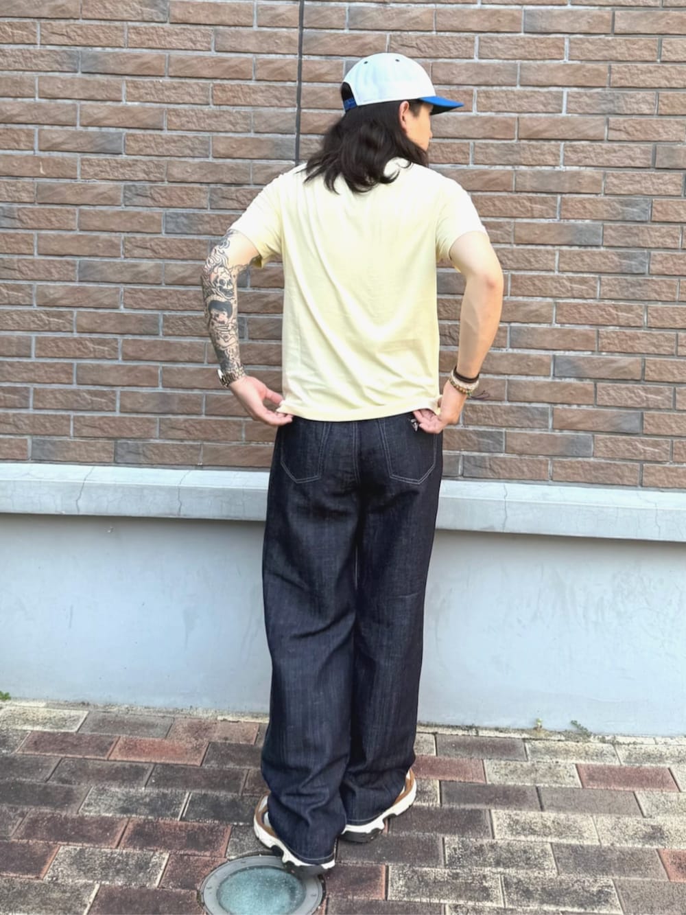 イエロー系のTシャツ/カットソー、ブルー系のデニムパンツを着用したメンズの夏コーディネートの2枚目の写真