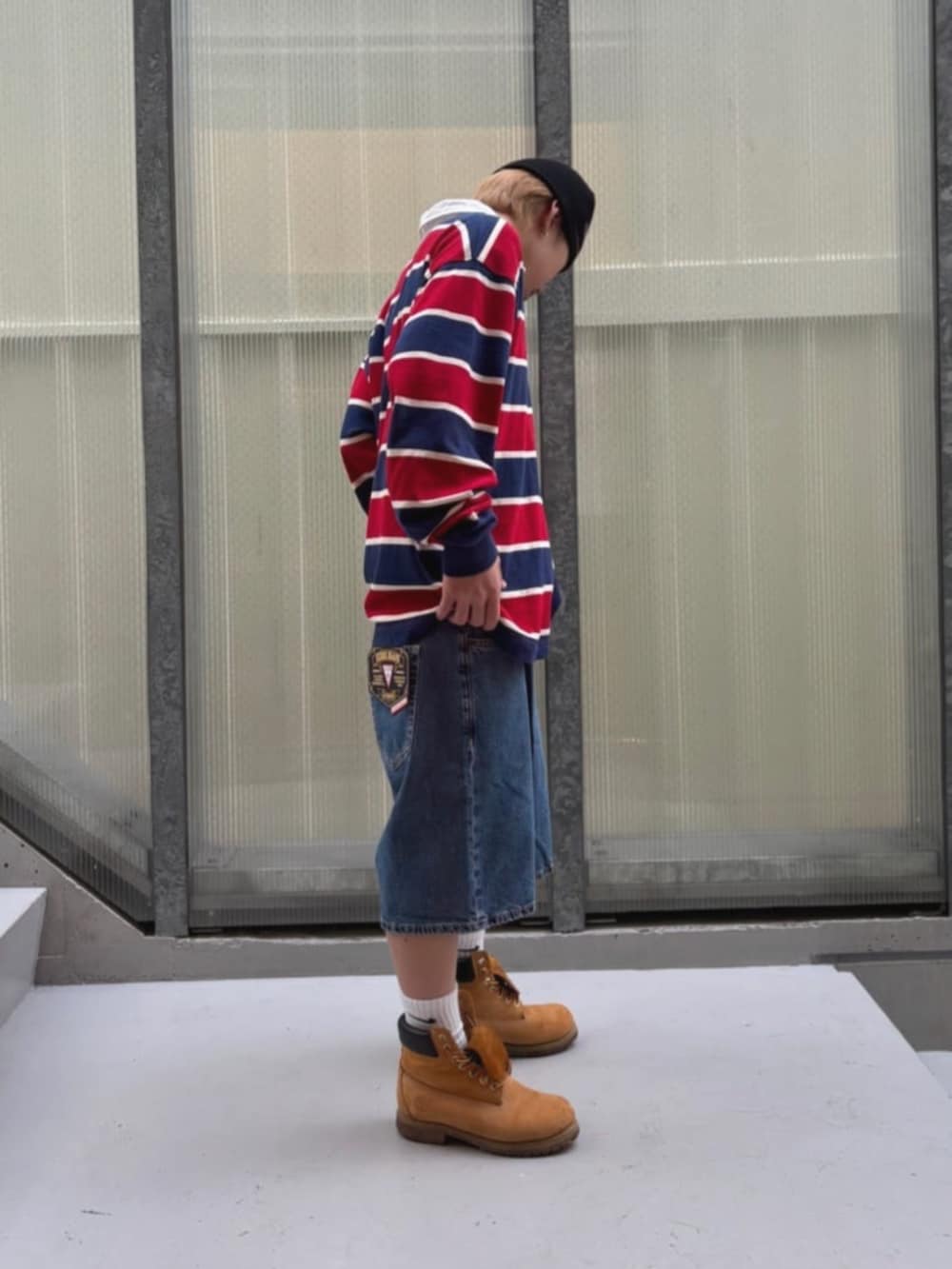 ホワイト系のTシャツ/カットソー、レッド系のポロシャツ、ブルー系のデニムパンツを着用したメンズの秋コーディネートの3枚目の写真