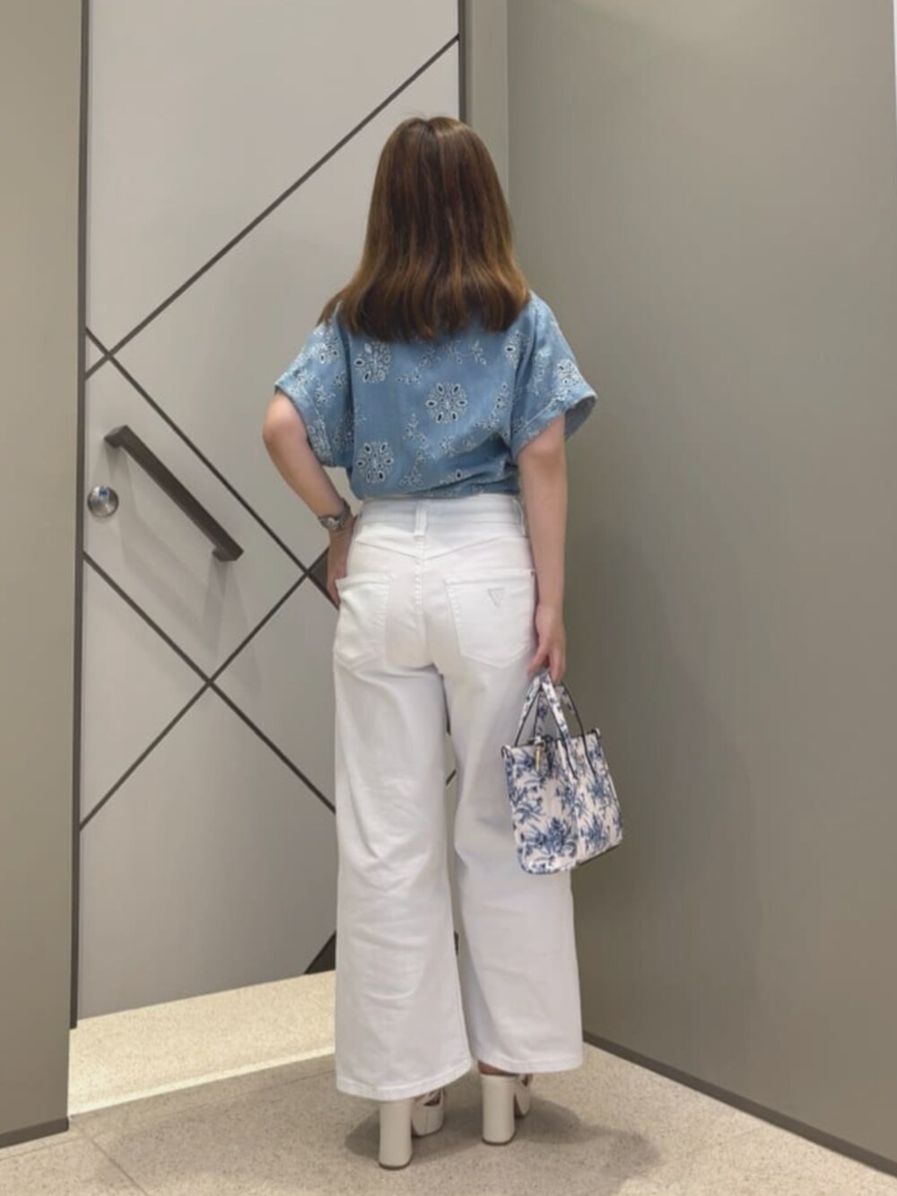 ホワイト系のショルダーバッグ、ブルー系のシャツ/ブラウス、ホワイト系のTシャツ/カットソーを着用したレディースの夏コーディネートの2枚目の写真