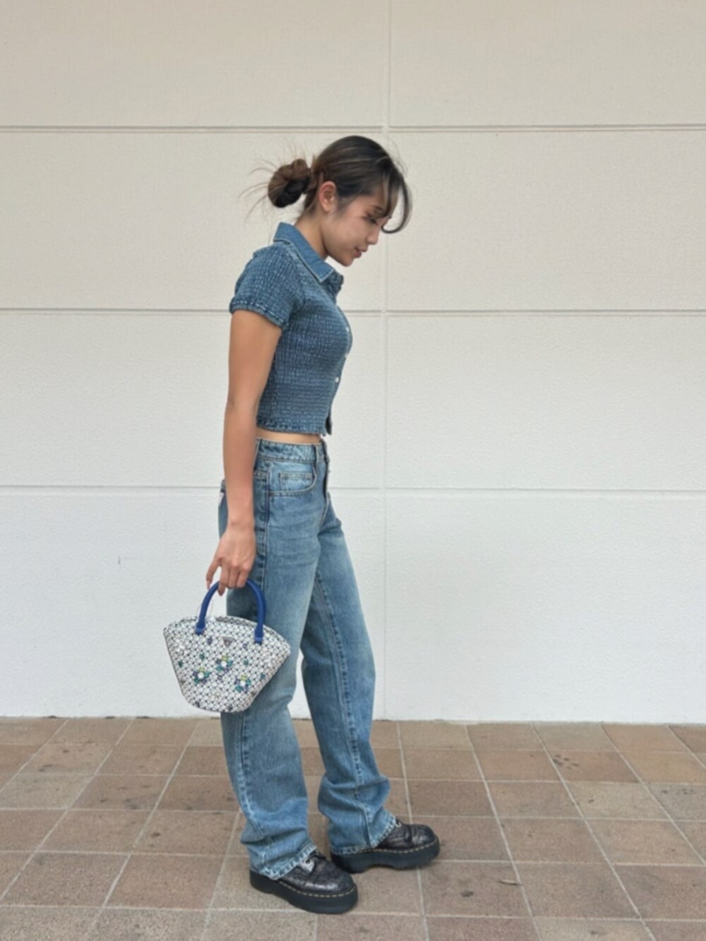 ブルー系のデニムパンツ、ブルー系のシャツ/ブラウス、ブルー系のショルダーバッグを着用したレディースの秋コーディネートの3枚目の写真