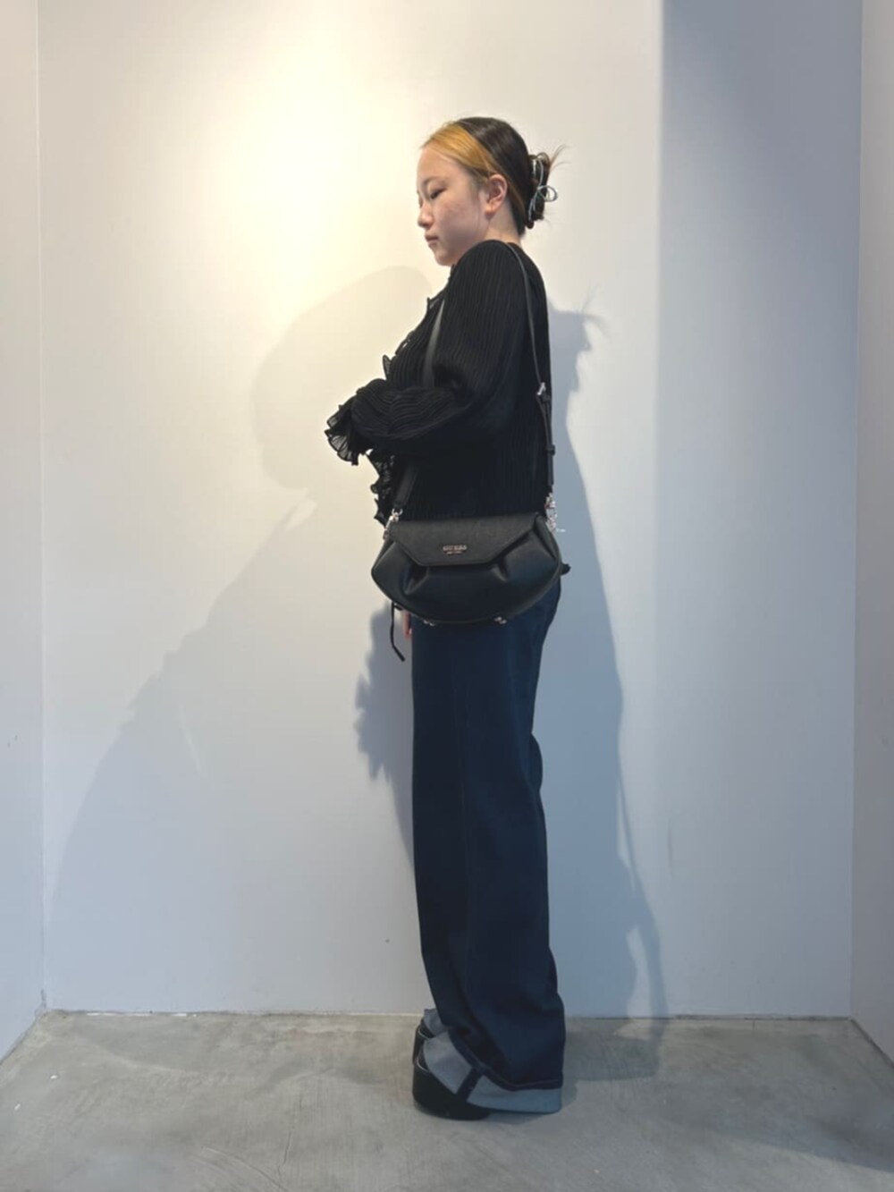 ブルー系のデニムパンツ、ブラック系のショルダーバッグ、ブラック系のシャツ/ブラウスを着用したレディースの冬コーディネートの3枚目の写真