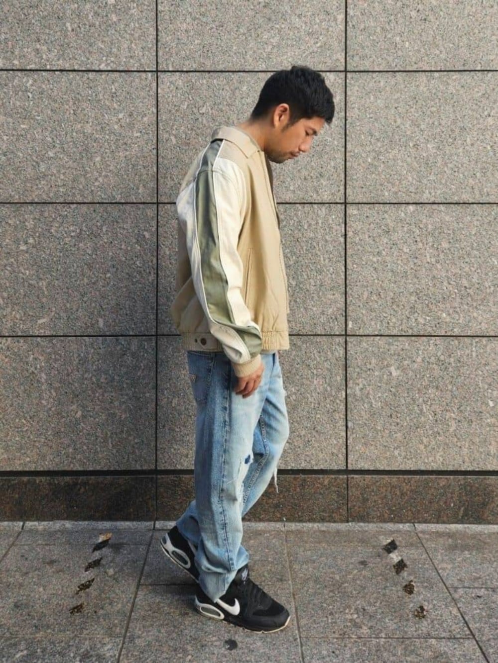 ブルー系のデニムパンツ、ベージュ系のその他アウター、グリーン系のTシャツ/カットソーを着用したメンズの秋コーディネートの3枚目の写真