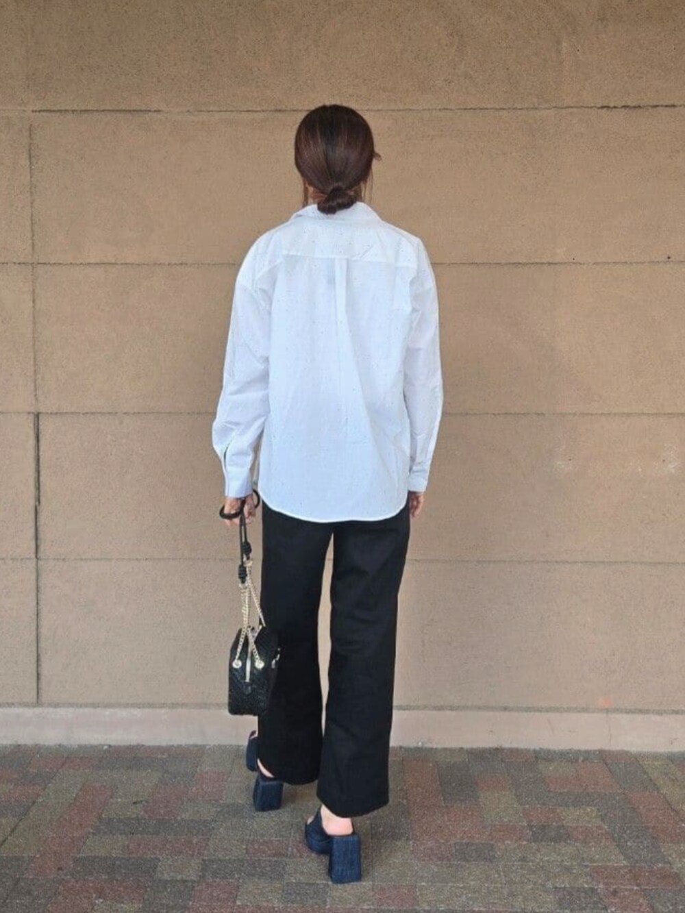 ブラック系のデニムパンツ、ホワイト系のタンクトップ、ホワイト系のシャツ/ブラウスを着用したレディースの夏コーディネートの2枚目の写真