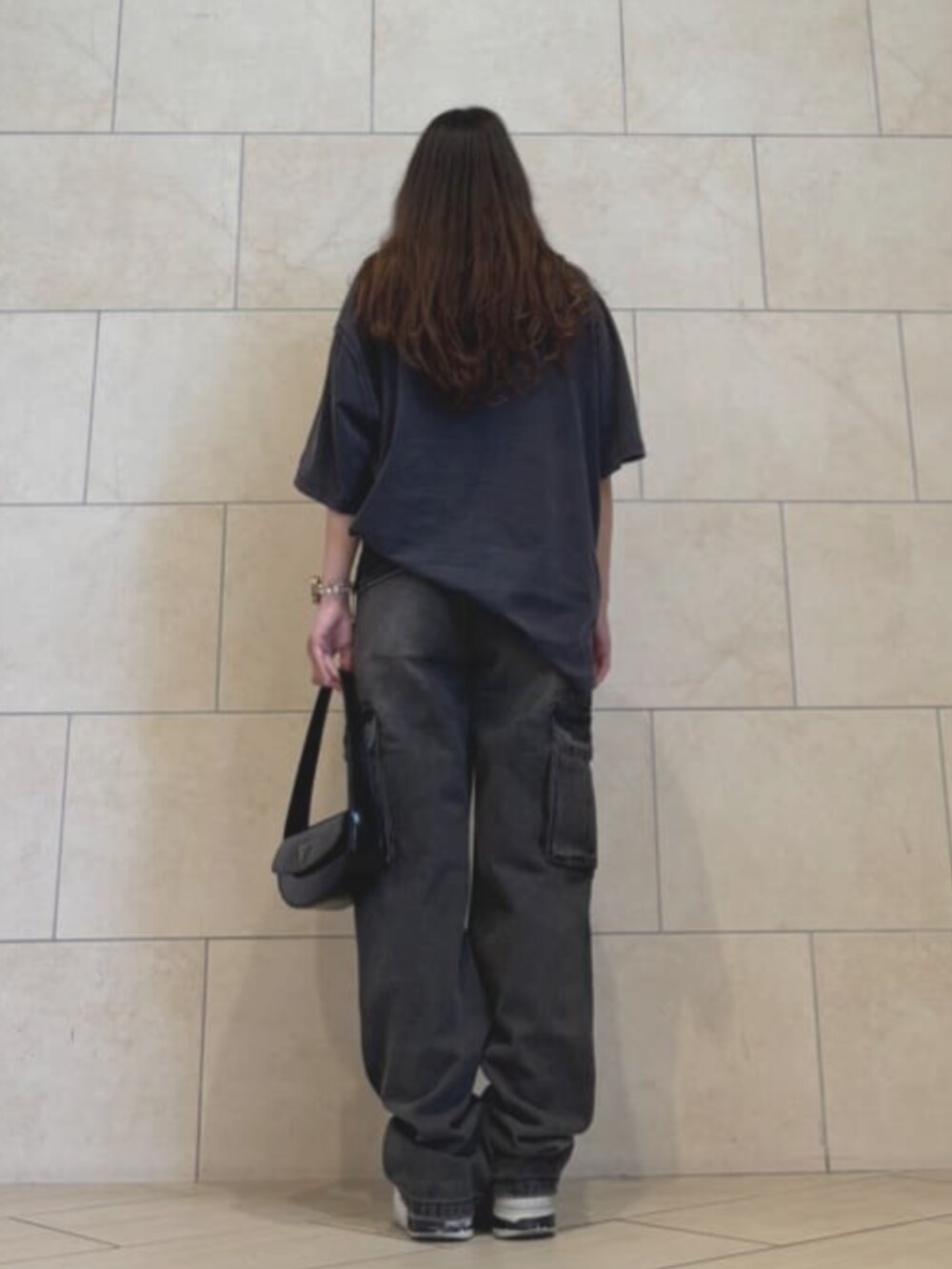 ブラック系のショルダーバッグ、ブラック系のデニムパンツ、ブラック系のTシャツ/カットソーを着用したレディースの夏コーディネートの2枚目の写真