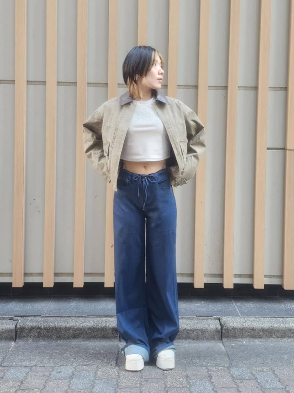 ホワイト系のTシャツ/カットソー、ブルー系のデニムパンツ、グリーン系のミリタリージャケットを着用したレディースの冬コーディネートの5枚目の写真