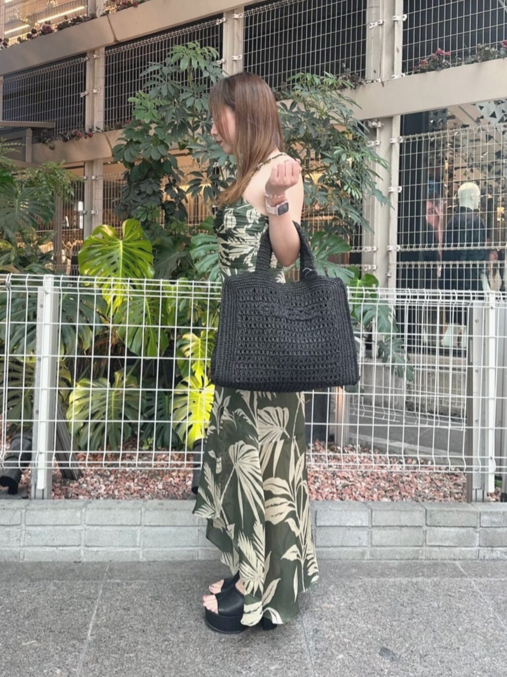 グリーン系のワンピース、ブラック系のトートバッグを着用したレディースの夏コーディネートの3枚目の写真